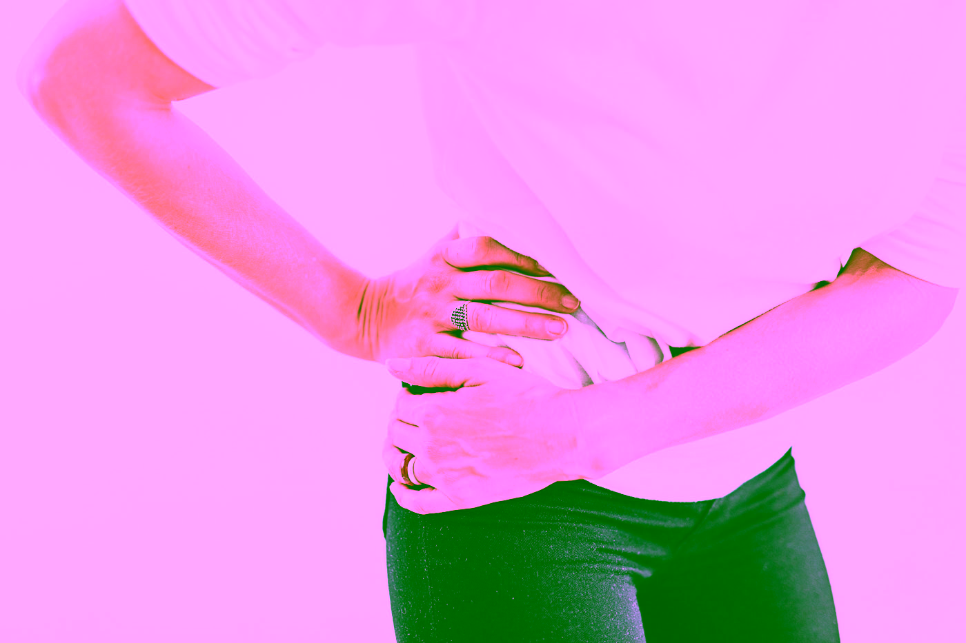 Eine Frau fasst sich mit beiden Händen an die Hüfte