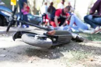 Ein E-Scooter liegt auf der Straße, im Hintergrund wird erste Hilfe geleistet