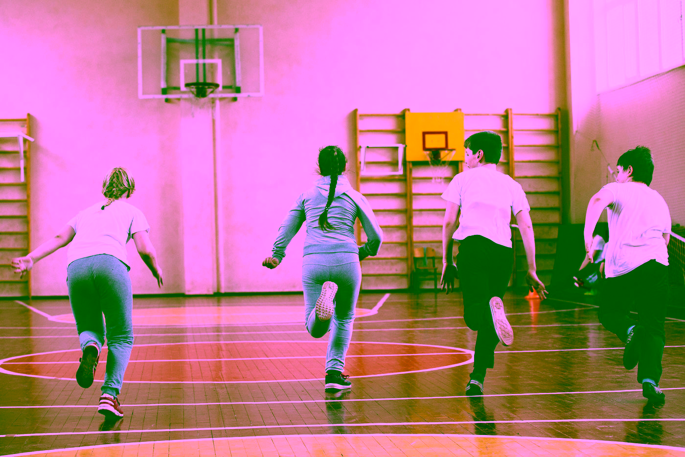 Kinder laufen in einer Turnhalle in Sportkleidung