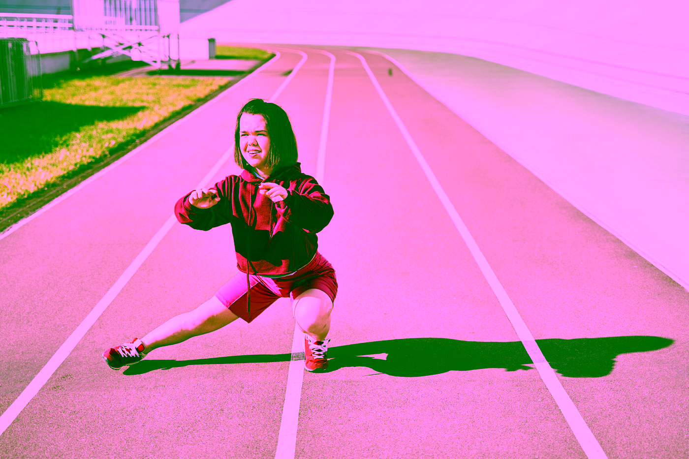 Kleinwüchsige Athletik wärmt sich in einem Stadion auf