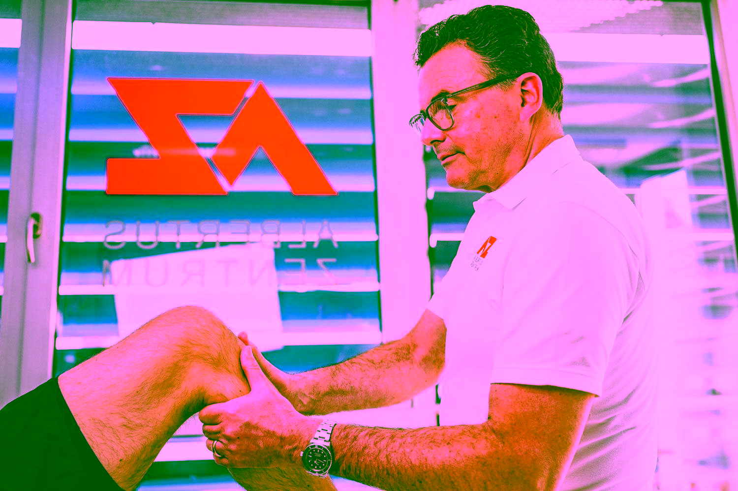 Orthopäde Dr. med. J. Heussen untersucht das Kniegelenk eines Patienten